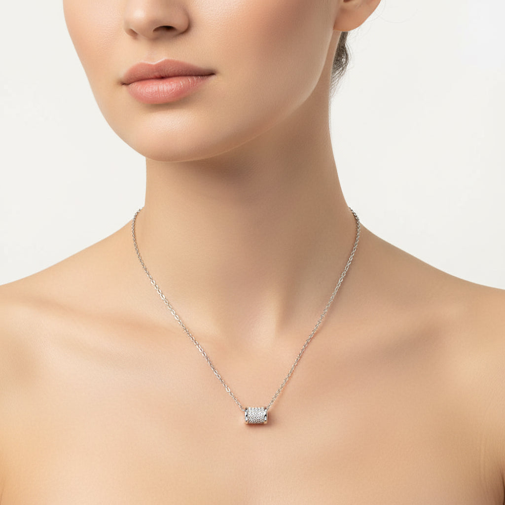 Silver necklace with a cylindrical pendant on a white background