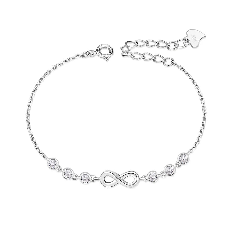 Silver bracelet with infinity symbol and heart charm on a white background