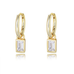 Gold hoop earrings with square gemstones on a white background