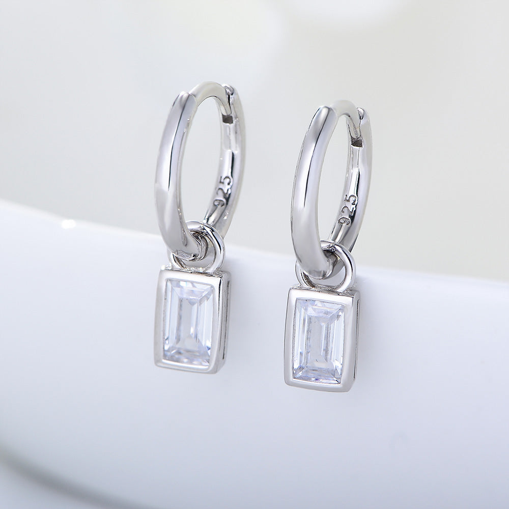 Silver hoop earrings with square gemstones on a white background