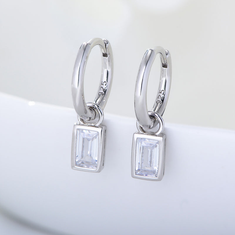 Silver hoop earrings with square gemstones on a white background