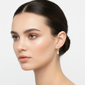 AURILYN Dainty CZ Drop Hoop Earring in 18K gold vermeil, worn on the ear with two round cubic zirconia stones.